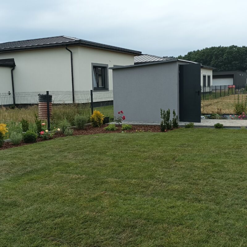 Zdjęcie przedstawiające trawę w rolce premium po rozłożeniu w ogrodzie w pochmurny i ponury dzień.