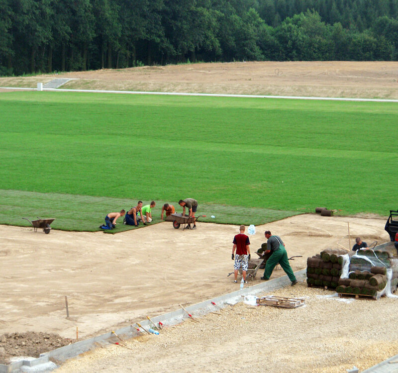 Zdjęcie przedstawia bardzo duże pole golfowe które jest w trakcie modernizacji a na mim jest rozwijana trawa w rolce Premium.