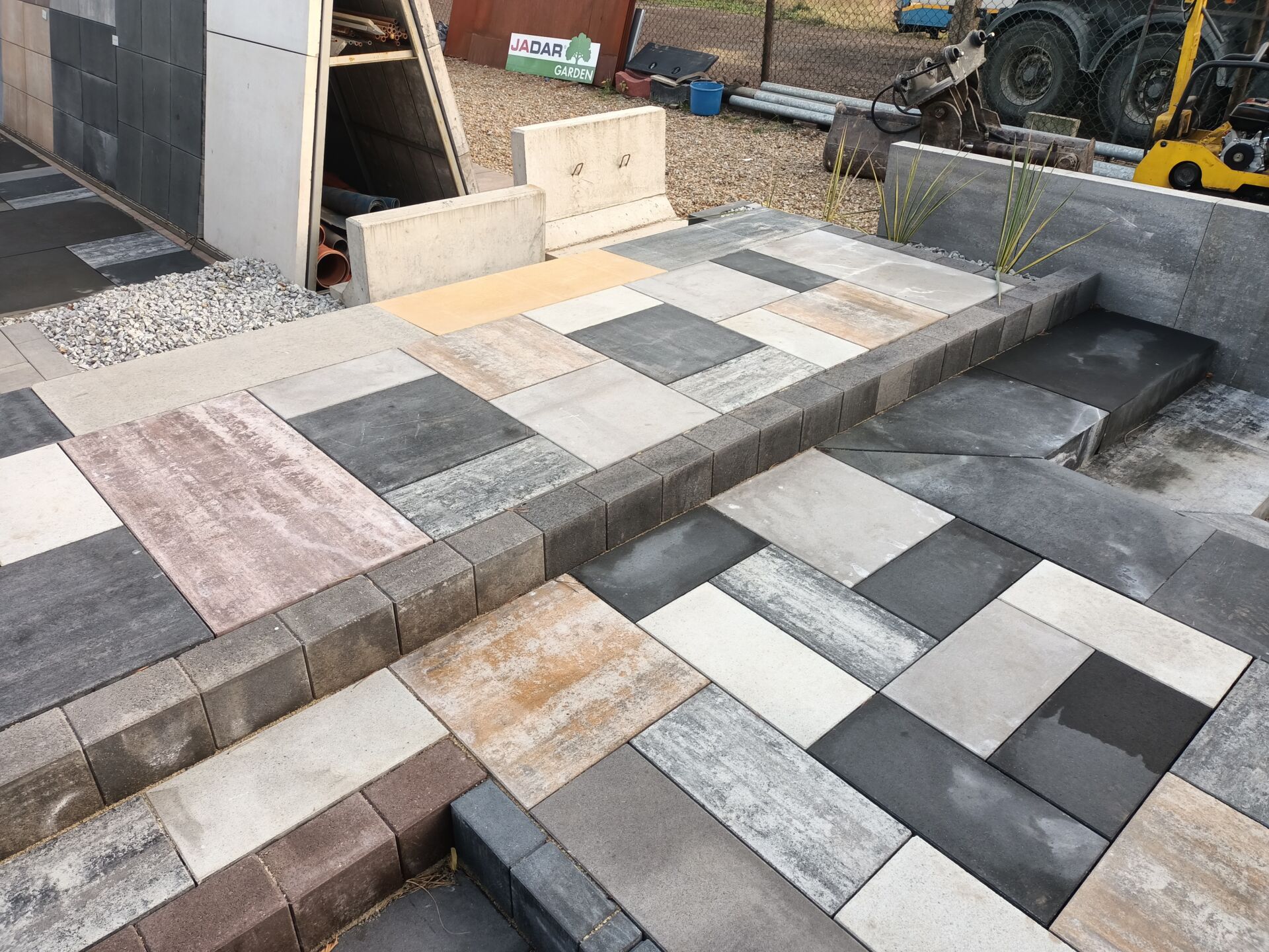 Zasięg i dostawa Rszmicio to cały kraj, zdjęcie przedstawia płyty ułożone w wielu kolorach, wzorach oraz na różnych poziomach tak by zilustrować możliwości do zastosowań na posesjach.